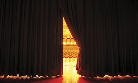Stage curtain being drawn to reveal theatre